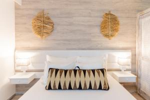 圣港Vila Baleira Suites的卧室配有白色的床和2张白色的桌子
