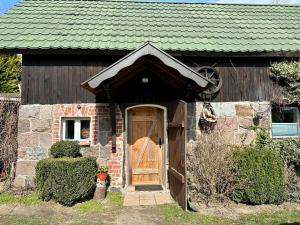 ŚwiekatowoApartament Loftowy- Bory Tucholskie的一座带木门和绿色屋顶的房子