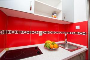 拉法洛维奇ACIKA apartments的红色的厨房,在柜台上放一碗水果