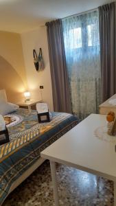 滨海波利尼亚诺Casa dei sospiri的客房设有两张床、一张桌子和一扇窗户。