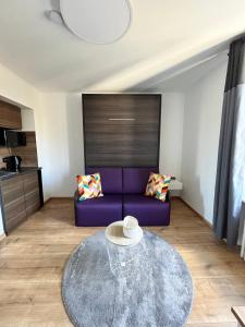 卢森堡Auberge de la Pétrusse的客厅配有紫色沙发和桌子