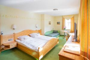 埃施韦格Hotel-Pension Eschwege的一间卧室配有一张床、一把椅子和电视