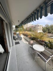 拉加尔德La Garde d'Antoine - Appartement centre ville的大楼内的阳台配有桌椅