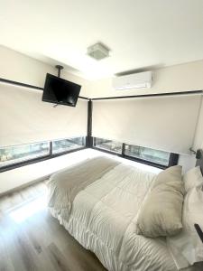 布宜诺斯艾利斯高尔夫大厦套房&公寓酒店的一间卧室配有一张床和一台平面电视