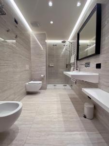 巴多利诺莱蒂齐亚别墅酒店的一间带两个盥洗盆、卫生间和淋浴的浴室