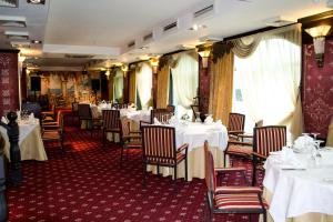 乌斯季卡缅诺戈尔斯克Shiny River Hotel的一间设有白色桌椅的用餐室