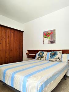维拉福林Apartamiento MEDITERRANI,VISTAS AL MAR,PISCINA!的一间卧室配有一张带蓝色和白色条纹棉被的床