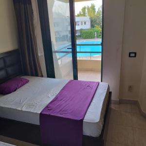 沙姆沙伊赫Juliee House-Criss Resort-Naama Bay的一间卧室设有一张床,享有游泳池的景色