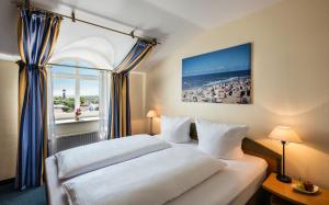 万根沃格Strandhotel Gerken的酒店客房设有一张床和一个大窗户