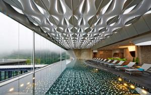 云顶高原Genting @ The MOST by NextGen的一座带椅子的建筑中央游泳池