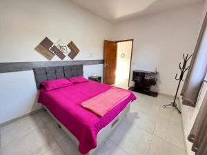 博尼图Aconchego e tranquilidade 1的一间卧室配有一张带粉色毯子的大床