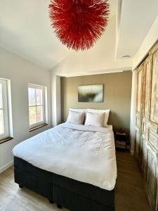 赫鲁德B&B Logement 't Slikje的一间卧室配有一张带红色吊灯的大床