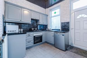 布雷得佛Stunning three Bed House in Bradford的厨房配有白色橱柜和窗户。
