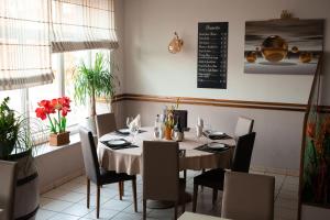 Gironcourt-sur-VraineLogis Hôtel Restaurant La Vraine的餐厅内带桌椅的用餐室