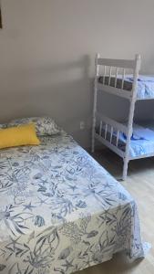 南圣弗朗西斯科Casa Praia&Ferias 300 metros Praia da Enseada的一间卧室配有一张床和一张婴儿床。