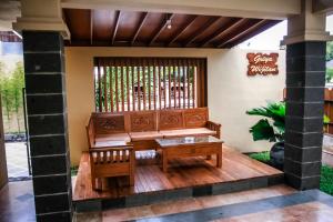 日惹格里亚维吉兰斯亚利亚酒店的一个带长凳和桌子的门廊
