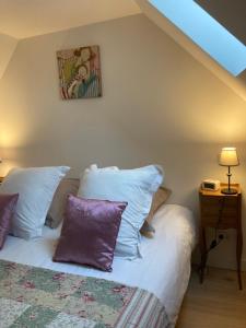 舍农索城堡Le Loft - Chenonceaux - 3 étoiles的一间卧室配有一张带紫色枕头的床