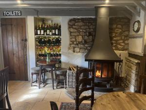 恩舍姆The Talbot Inn的客房设有壁炉、桌椅和葡萄酒瓶