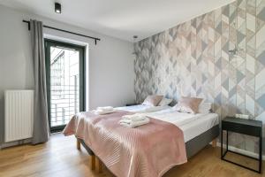 格丁尼亚LTC - Apartments Art Deco Śródmieście的一间卧室配有一张床,上面有两条毛巾