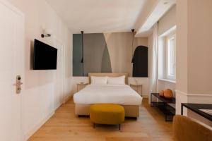 罗马Sonder Antinoo的一间卧室配有床和黄色凳子