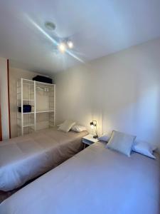 马尔格莱特德玛Atico duplex en Malgrat de Mar的一间卧室设有两张床,天花板上拥有灯光