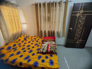 普杰My Nest - Best Homestay for Peaceful Stay with Comfort的一间卧室配有黄色的床,床上有蓝色的鲜花