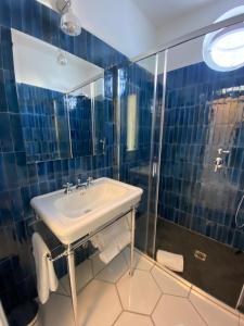 卡普里CASA ELISA的蓝色瓷砖浴室设有水槽和淋浴