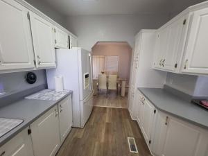 帕伦普Sun Angel House #1 Pahrump的厨房配有白色橱柜和白色冰箱。
