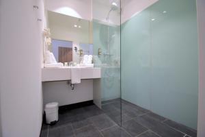 采德豪斯Sporthotel Zederhaus的一间带水槽和玻璃淋浴的浴室