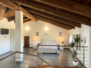 特雷伊索Il Girasole Apartments的一间带一张床的卧室,位于带木制天花板的房间内