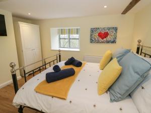 Upper SapeyOld Farm Cottage的一间卧室配有一张大床,提供黄色和蓝色的枕头