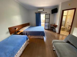 波苏斯-迪卡尔达斯米纳斯花园酒店的酒店客房,设有两张床和一张沙发