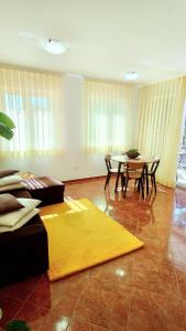 罗维尼萝拉公寓的客厅配有桌子和黄色地毯