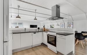 布拉万德Stunning Home In Blvand With 4 Bedrooms, Sauna And Indoor Swimming Pool的厨房配有白色橱柜和炉灶烤箱。