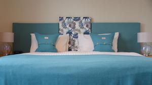 威廉堡Torlinnhe Guest House的一张带蓝色毯子和枕头的床
