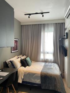 圣保罗Allianz Parque Studio em São Paulo的一间卧室配有一张床、一张书桌和一个窗户。
