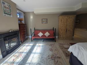 霍普港Farmhouse Suite的一间卧室配有红色的沙发和壁炉