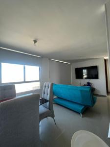 哥伦比亚港apartamento barranquilla villa campestre!的客厅配有蓝色的沙发和电视