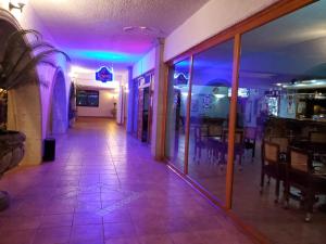 San QuintínHOTEL MISION SANTA MARIA的餐厅里一个空的走廊,有紫色的灯