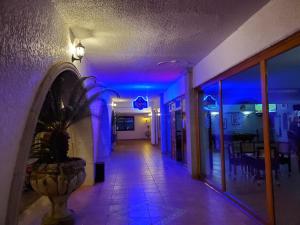 San QuintínHOTEL MISION SANTA MARIA的蓝色灯的建筑走廊