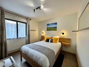 阿梅尔斯克维Les Chambres Du Vignoble的一间卧室配有一张带黄色枕头的床和一扇窗户