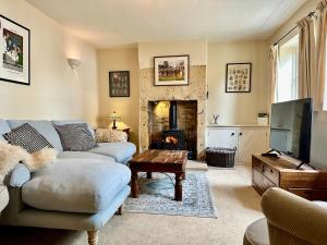 奇平卡姆登Camside, Chipping Campden - Taswell Retreats的带沙发和壁炉的客厅