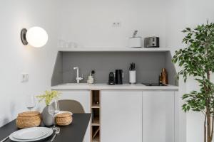 多特蒙德BRIGHT Dortmund City Center的厨房配有白色橱柜和一张带盘子的桌子