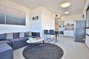 海法Breeze” luxury apartment”的客厅配有蓝色的沙发和桌子