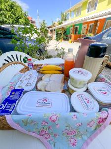 邦比尼亚斯Pousada Flores de Bombinhas的野餐桌上放有盘子和食物