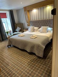 Sanquhar尼斯河谷旅馆的一间卧室配有一张大床和两条毛巾