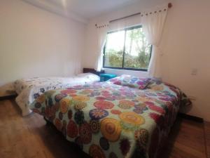 萨兰托ALOJAMIENTO EL REGALO的一间卧室配有一张带鲜花毯子的床和窗户。