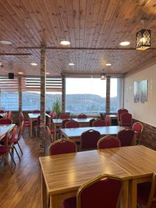 瓦迪穆萨Petra cabin Roof top hostel的用餐室配有桌椅和大窗户
