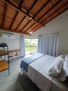 佩德拉阿祖尔Villaggio Ronchi的一间卧室配有一张床、一张书桌和一个窗户。