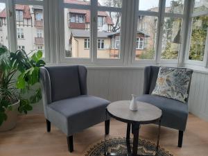 索波特Berni's home Apartament z tarasem的带窗户的客房内配有两把椅子和一张桌子